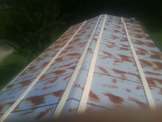 Rusted metal roof panels with new wood purlins before replacement — Storm Damage Roof Repair in Beltsville by Roofing Brothers