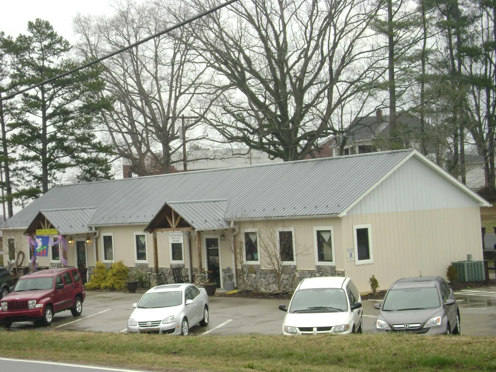 Gray metal roof with timber entry brackets on a small commercial building in Beltsville