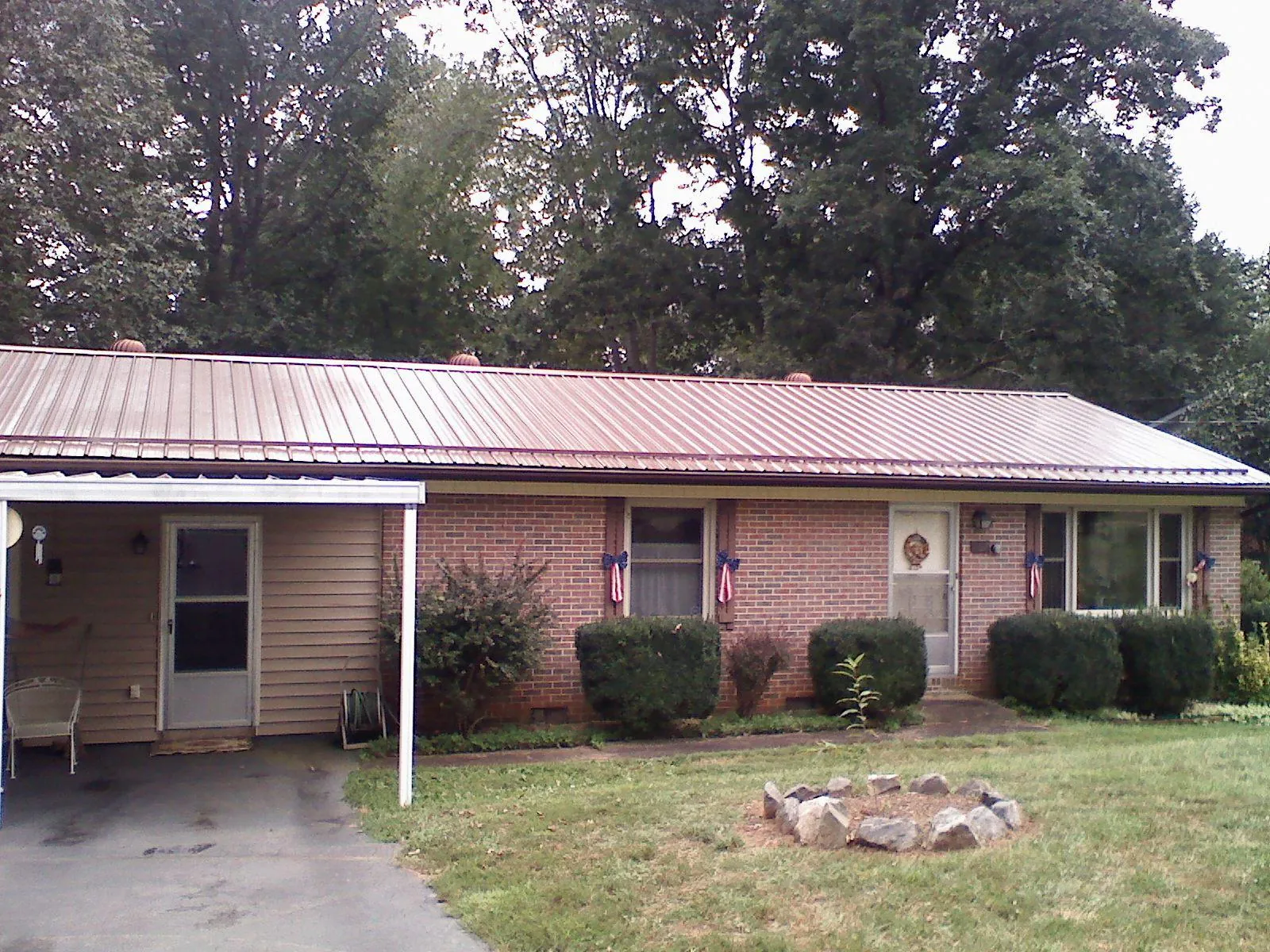 Bronze metal roof and carport on a brick ranch home — Roof Repair work by our crew in Beltsville