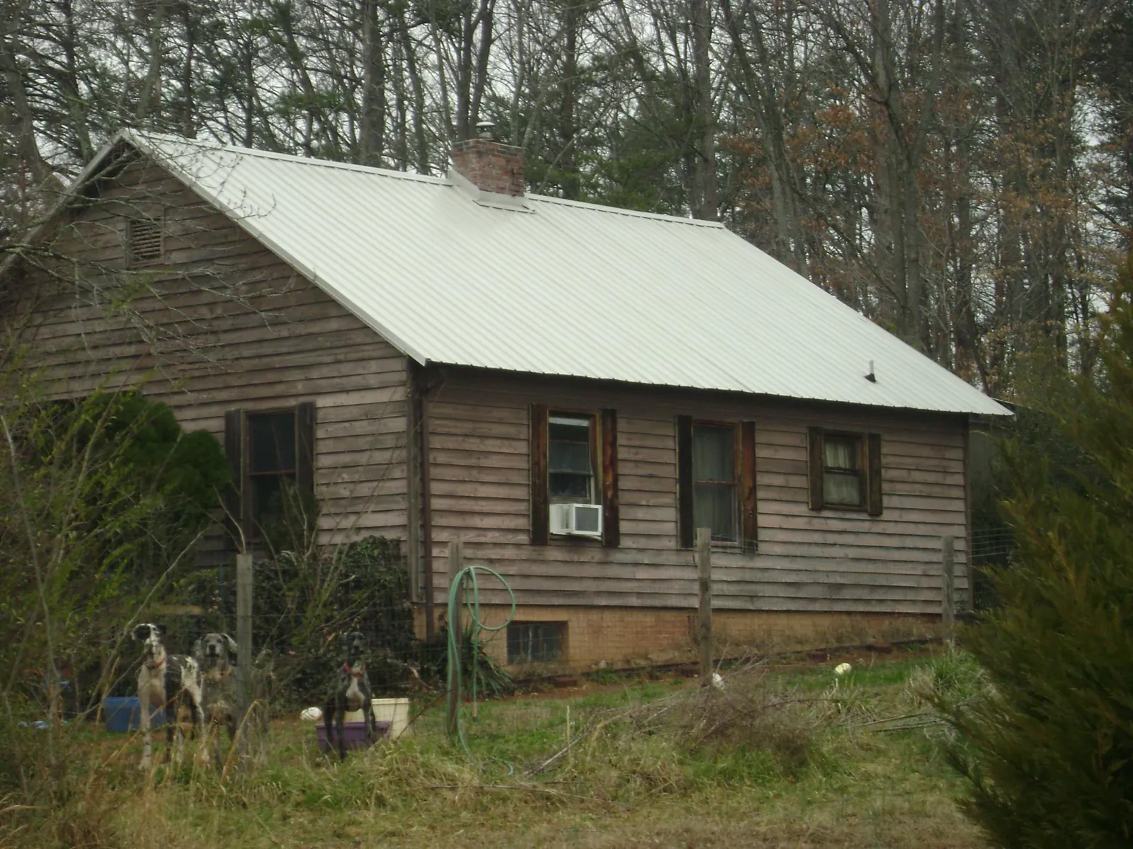 White metal roof on an old wood sided farmhouse, from a Metal Roof Installation job in Beltsville